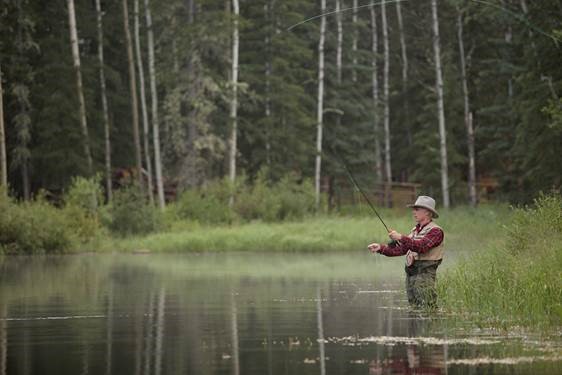 man fly fishing in a pond